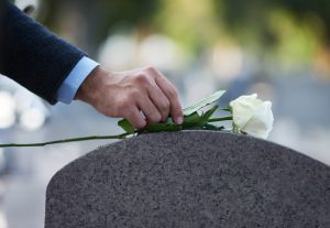 a white rose placed on a grave stone